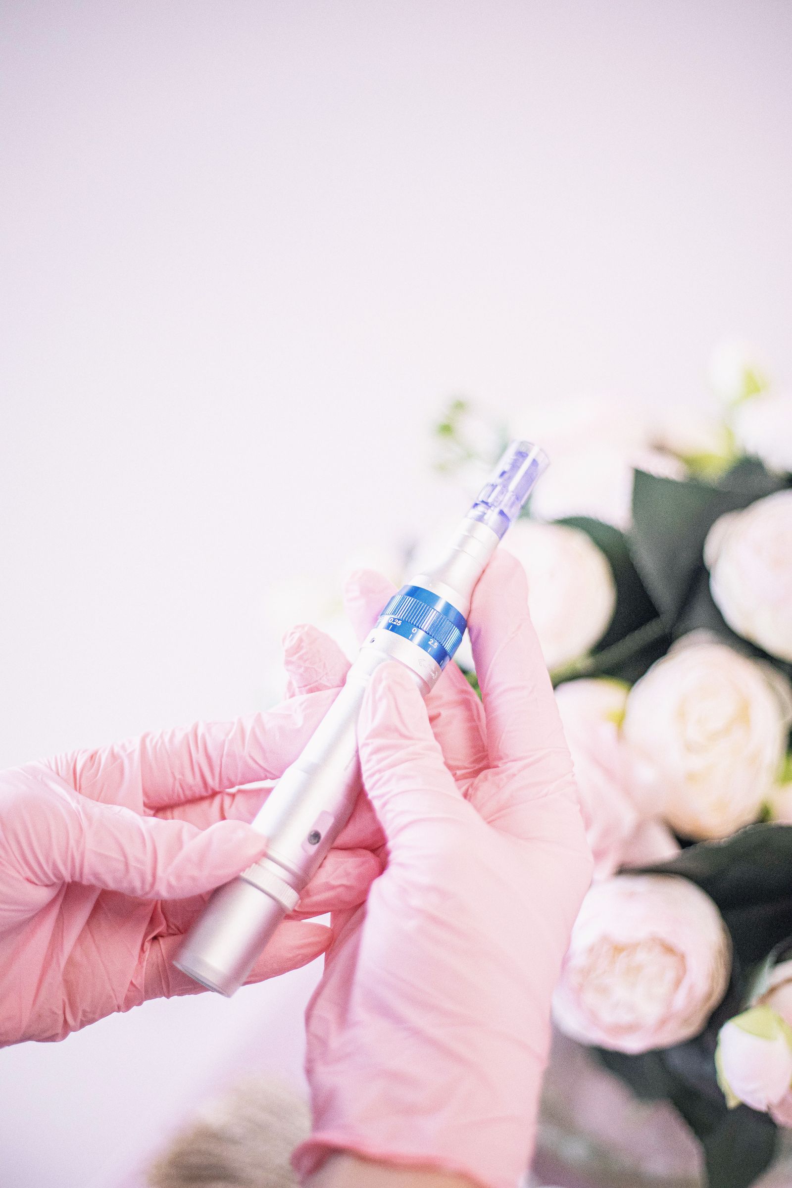 Mains gantées tenant un stylo à micro-aiguilles