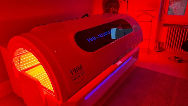 Cabine de photobiomodulation corps entier du Centre PBM M&eacute;dicale, allum&eacute;e en lumi&egrave;re rouge